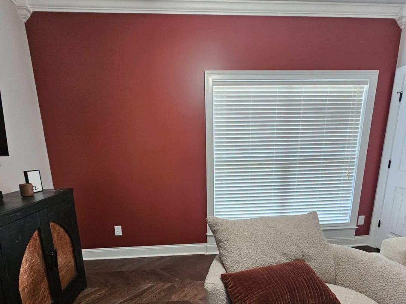 Interior painting: the same living room after, with a deep red accent wall.