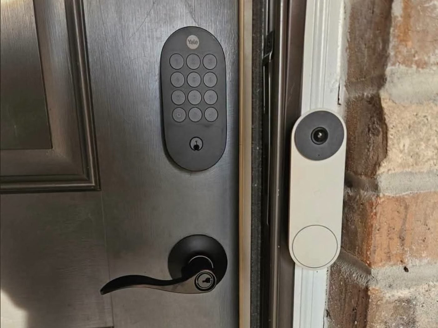 Door hardware and smart lock installation: a front door with a Yale keypad deadbolt and matching black lever handle installed.