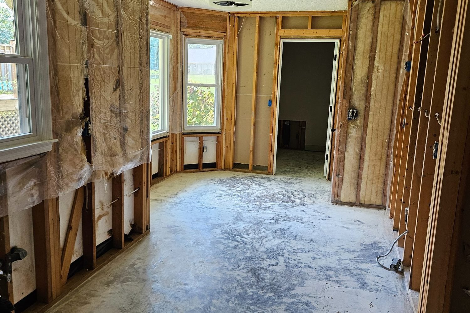 Before the renovation: a sunroom stripped to bare studs with exposed insulation.